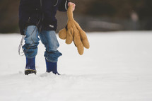 boy child walking in the snow holding a teddy bear 