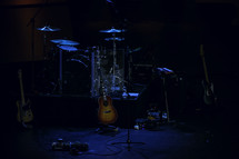 drum set, symbols, and guitar on stage 