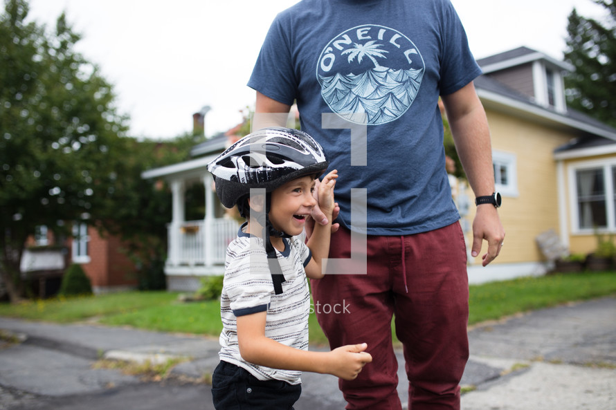a father helping his son rollerblade 