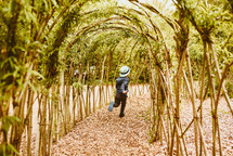 a child running through arched plants in the botanical gardens 