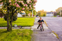 boy outdoors in a sweater riding a bike 