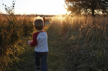 children running in a field at sunset 