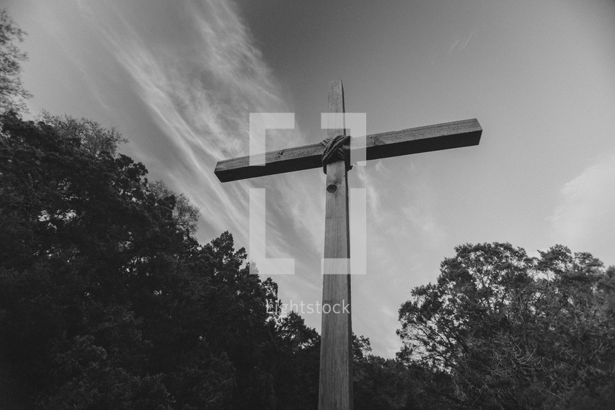 A large wooden cross rises toward the sky.