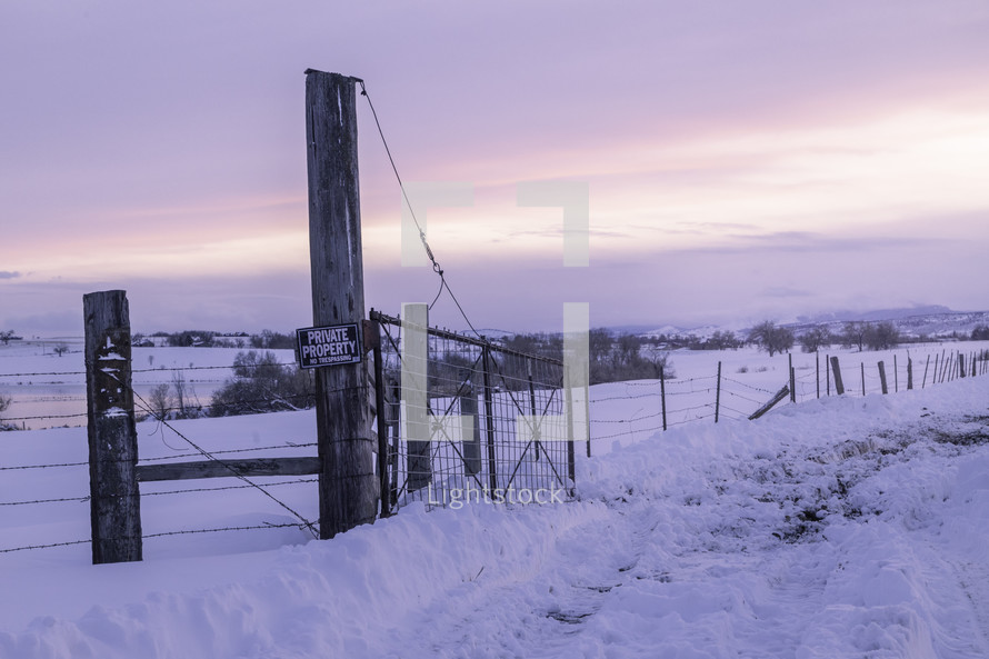 The barbed wire fence leads along the winter landscape scenery after a snow storm