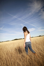 Girl walking through a wheat field