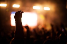 hands of an audience under concert lights