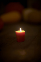 Lit candle on wooden table