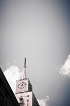A clock sits high atop a building.