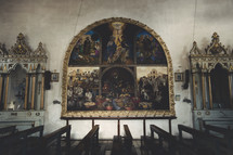 Christian paintings hung above pews inside a church sanctuary