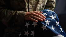 Soldier caressing the stars of a usa Flag on veterans day