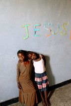 Jesus written on the wall over two children of God