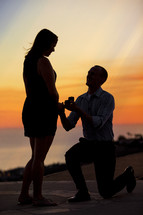 man on his knee proposing to a woman 