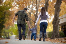 Mother and father walking outdoors with toddler