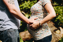 a man with his hand on a pregnant woman's belly 