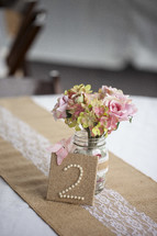 flowers in a vase on a table at a wedding reception 