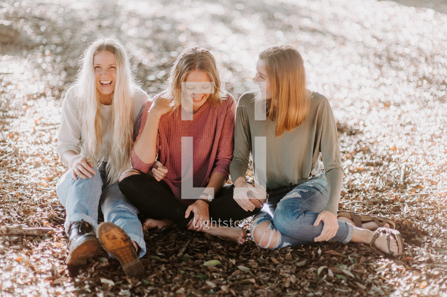 three women sitting on the ground 