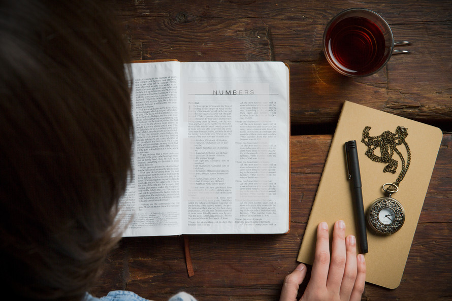 Reading the Bible on a wooden table.