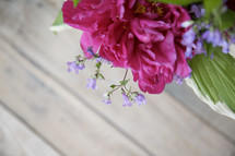 fuchsia flowers in a vase on a wood table 
