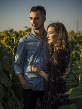 a couple standing together in sunflowers 