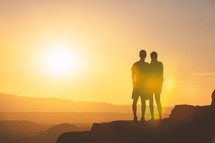 silhouette of a couple at sunset on a mountaintop 