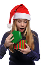 girl in a santa hat opening a Christmas present 