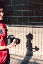 woman and shadow holding a camera 