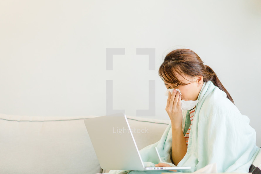 a sick woman looking on a computer screen 