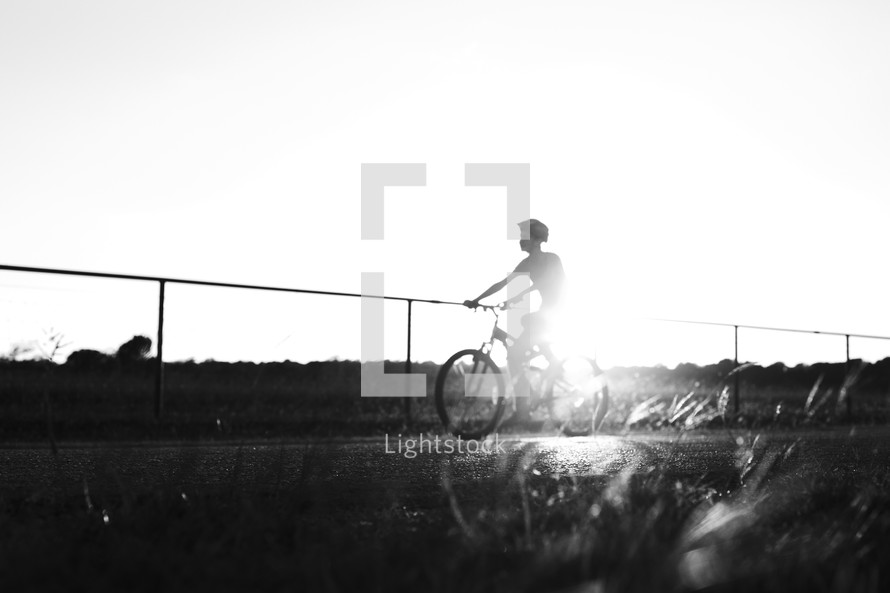 a teen boy riding a bicycle 