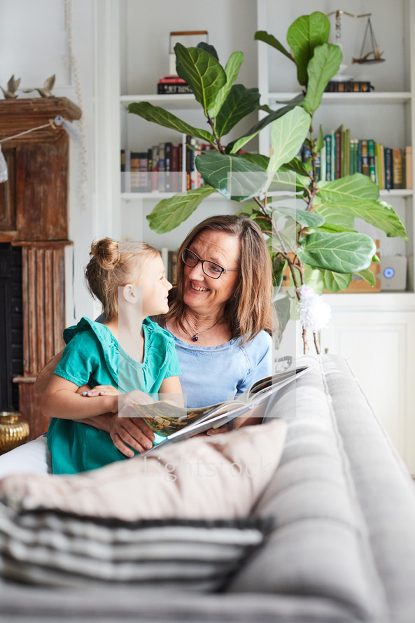 grandmother reading a book to her granddaughter 