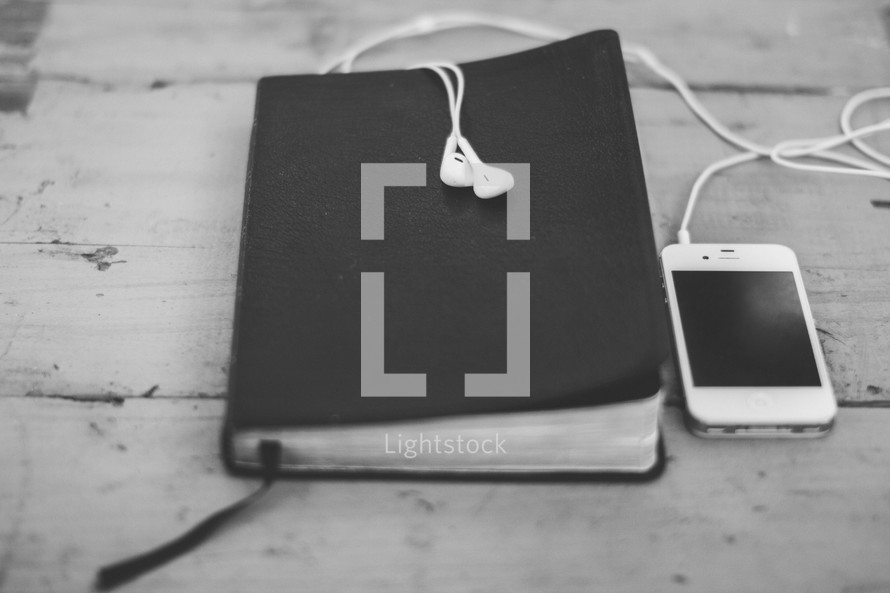 Bible, iPhone, and earbuds 