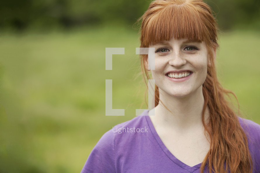 portrait of smiling red headed teenage girl