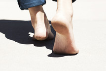 Bare feet walking on cement.