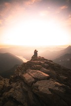 woman with a camera taking a picture on a mountaintop 