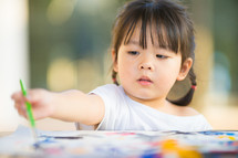 a toddler girl painting 
