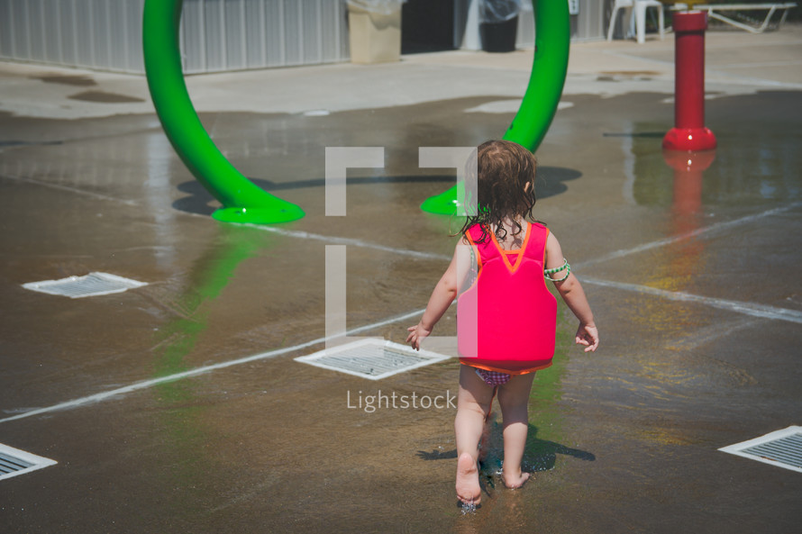 a little girl at a splash park 