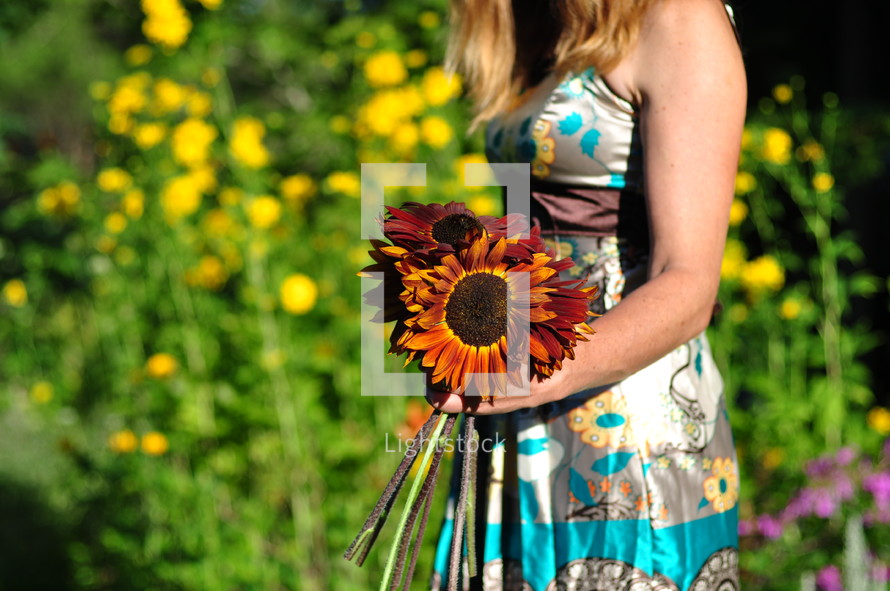 Girl carrying sunflowers.