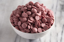 bowl of Authentic Ruby Chocolate Drops on a Marble Counter