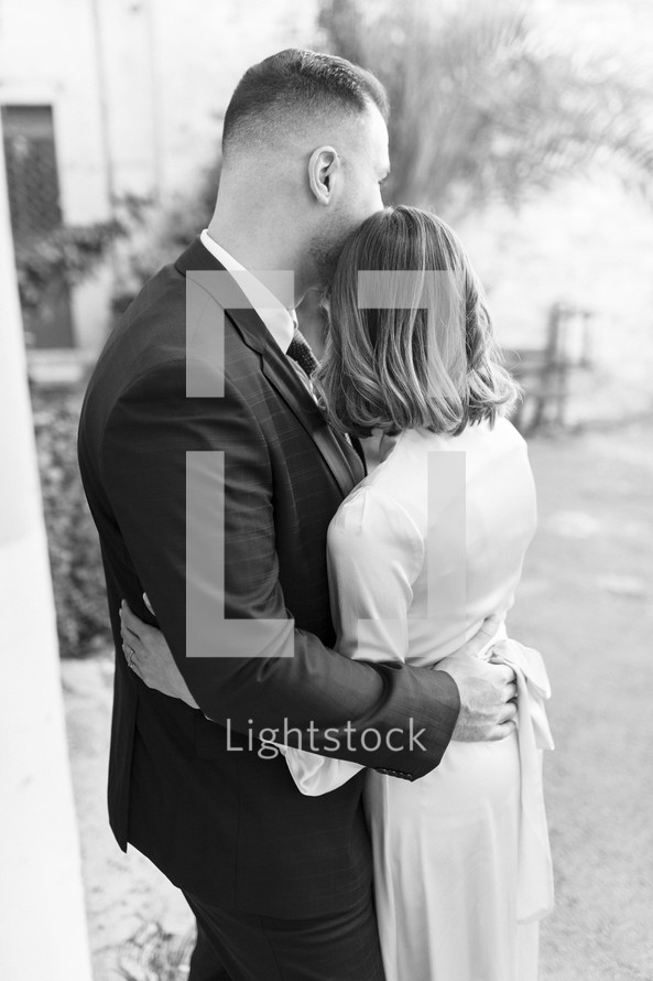 Husband and wife hugging each other on their wedding day.