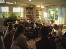 youth group sitting in a family room playing songs and singing together 