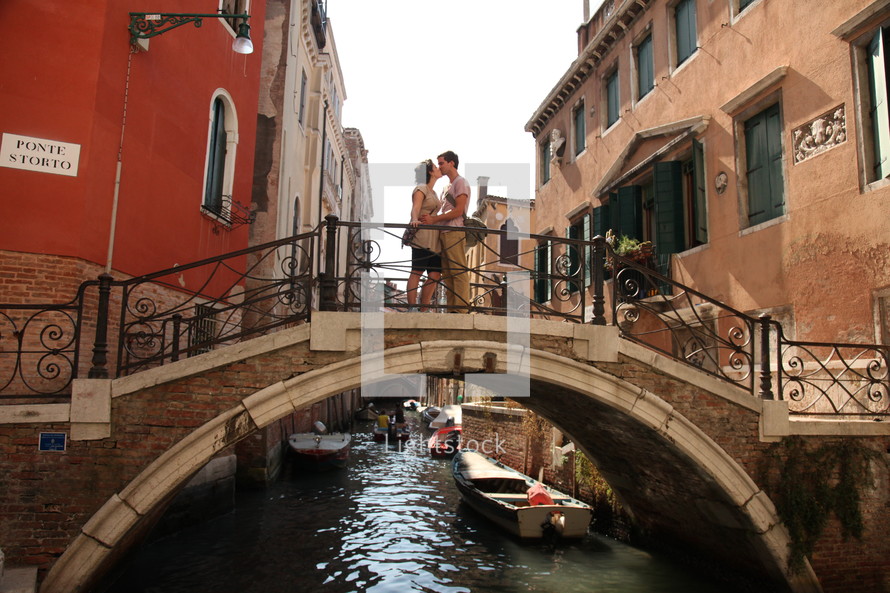 couple kissing on a bridge over a canal in Venice 