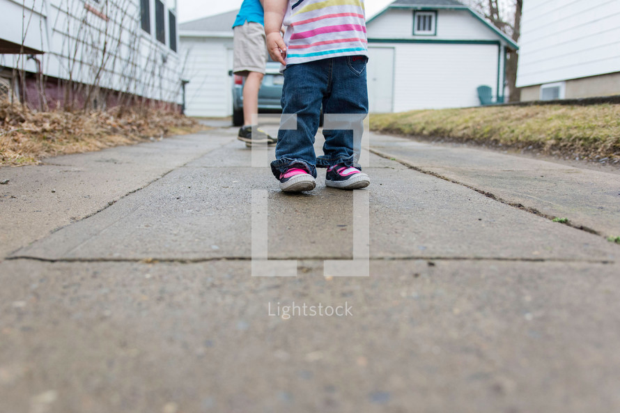 Children standing on a sidewalk