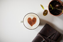 cinnamon heart in a coffee cup, Leather bound Bible, and house plant 