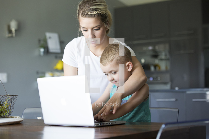 a mother teaching her son to use a computer 