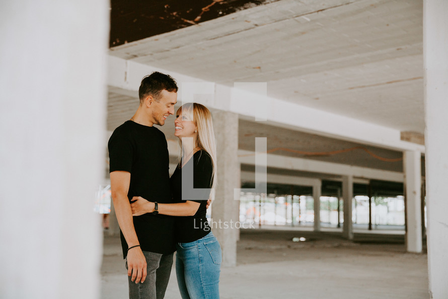 couple hugging in a parking garage 