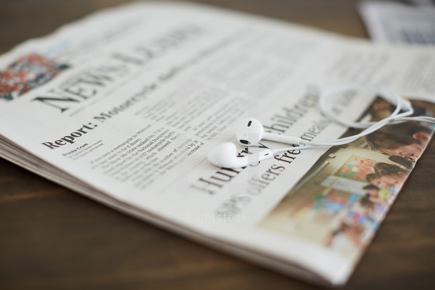 earbuds on a newspaper 