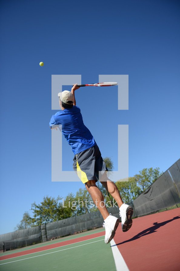 A tennis player swinging at a ball on a tennis court.