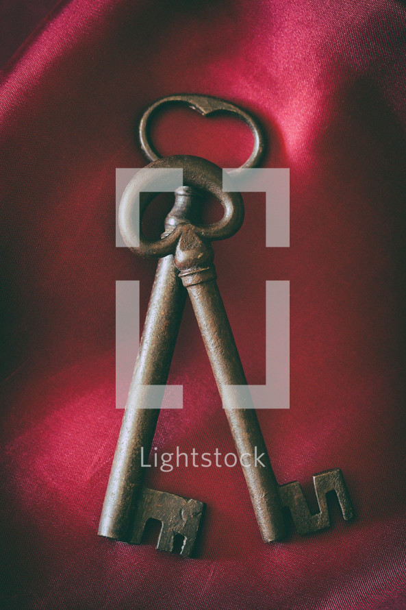 Ancient medieval wrought iron key on red background