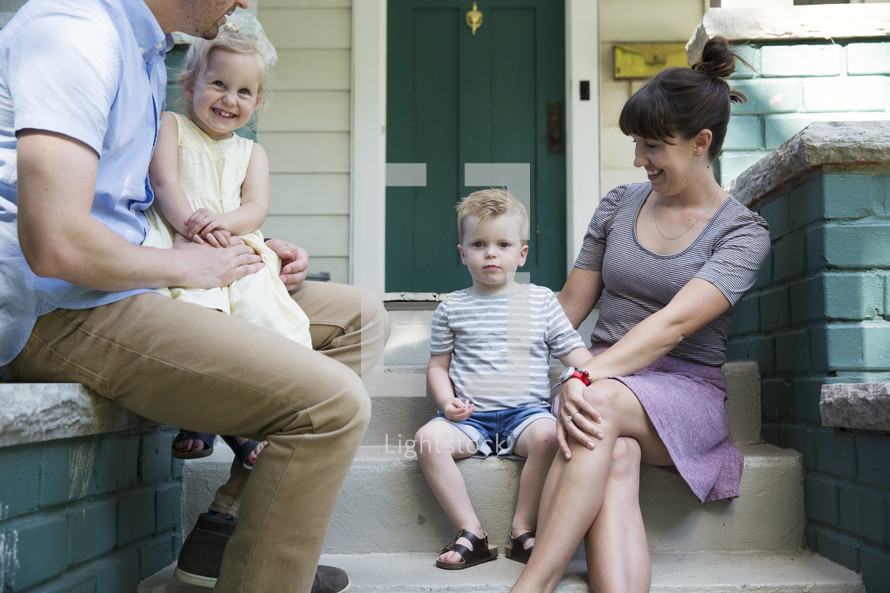 a family sitting on front porch steps 