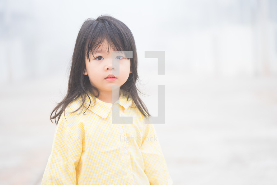 Little asian girl homeless standing alone on fog on the road .Kidnap Concept. Homeless kid