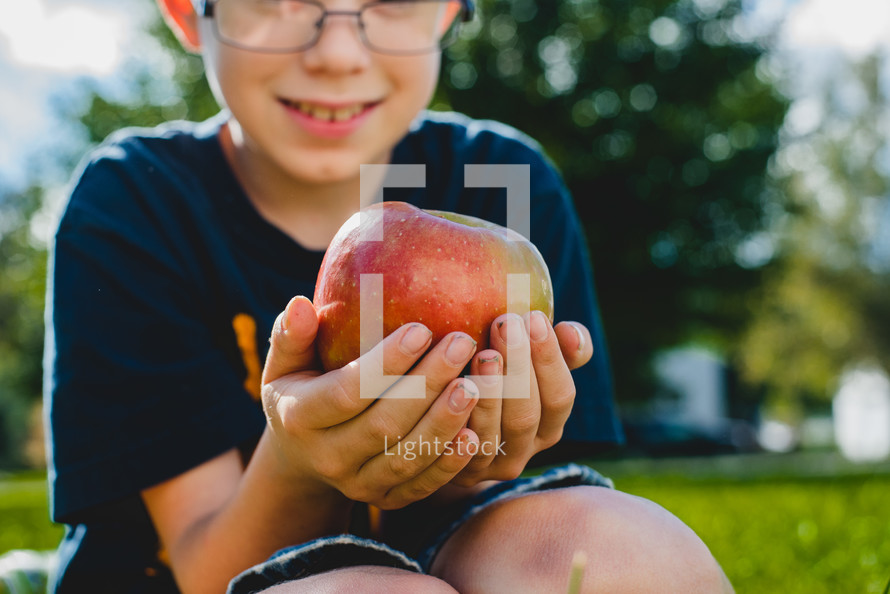 a boy holding an apple 